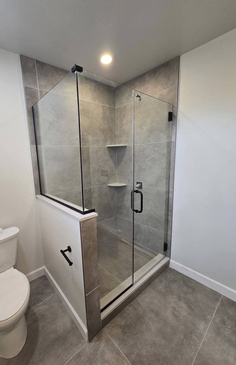Frameless glass shower door in a compact New Jersey bathroom