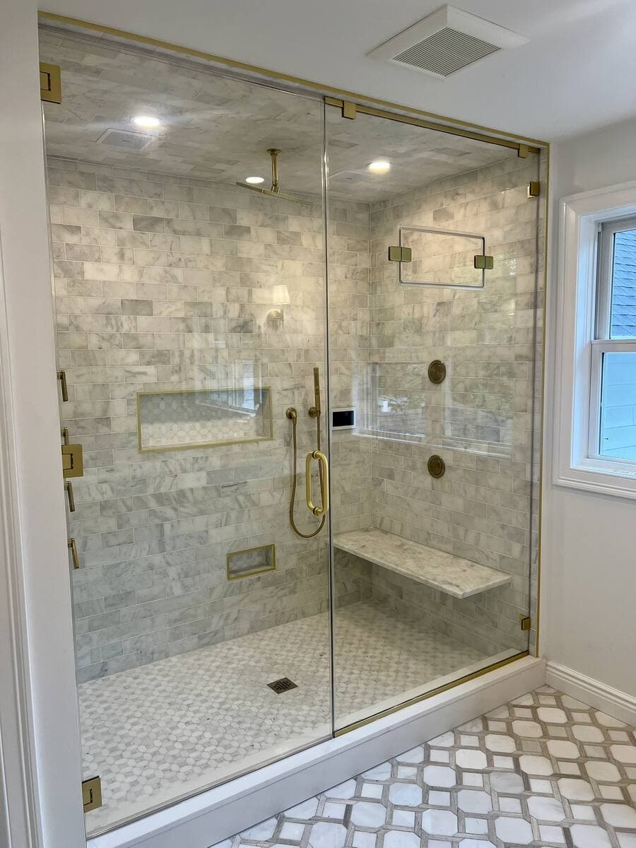 Marble shower with gold-finish frameless glass enclosure