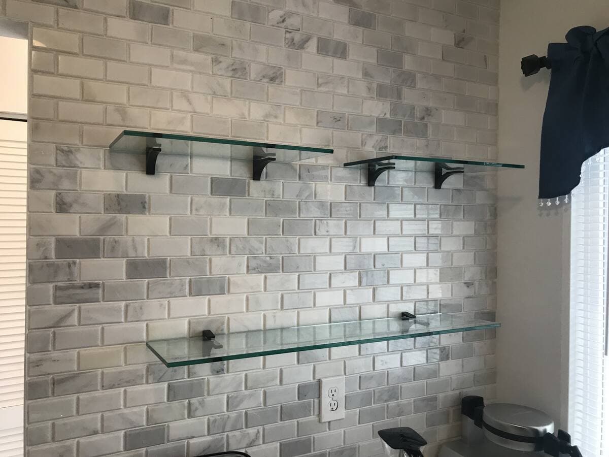 Custom glass shelves mounted on wall brackets